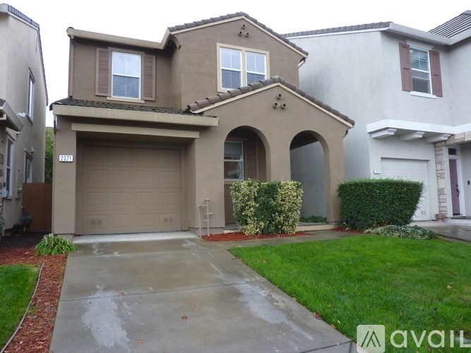 A house with a garage and a driveway in front.