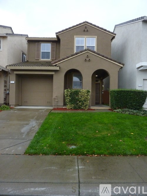 A house with a brown roof and a green lawn in front.