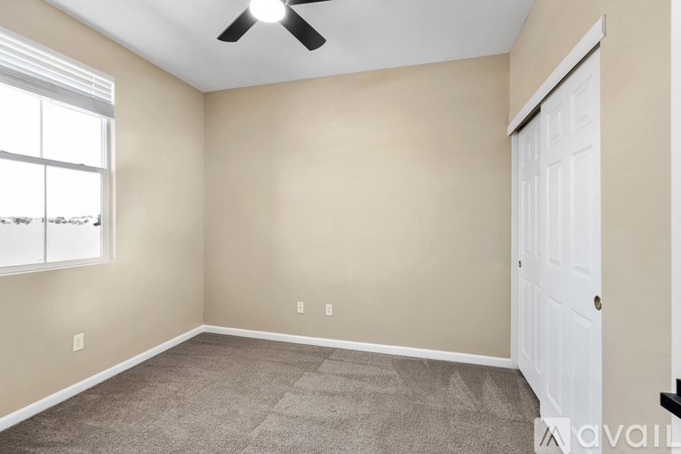 A room with a ceiling fan and a window.