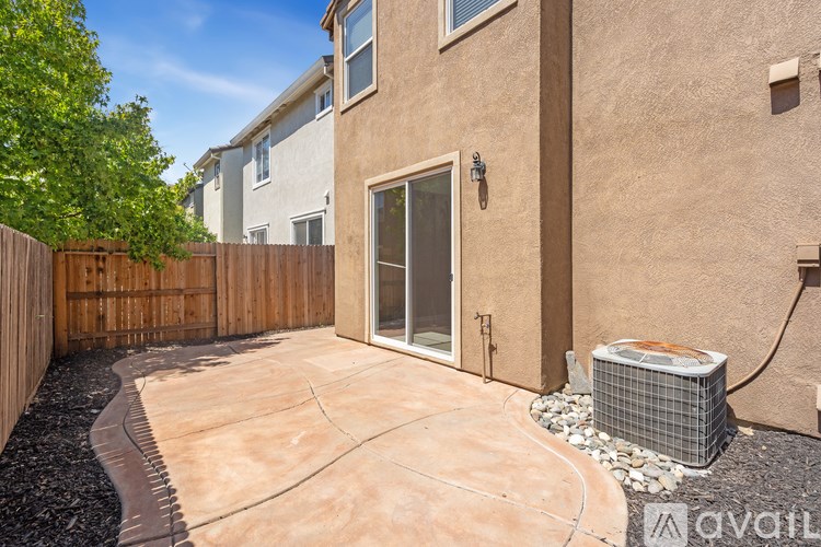 A house with a patio and a wall-mounted air conditioner.