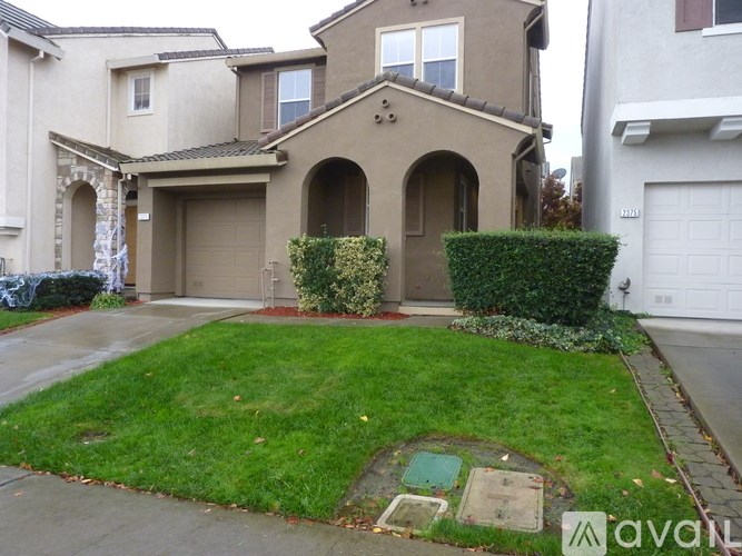 A house with a well-maintained lawn and a driveway.