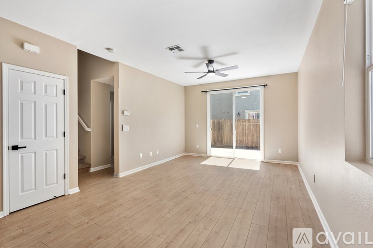 A room with a white door and a ceiling fan.