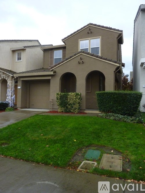 A house with a brown roof and a green lawn in front.