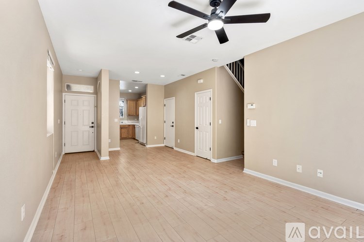 A spacious room with a ceiling fan and wooden flooring.
