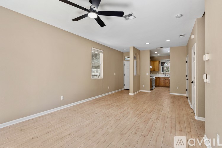 A spacious room with a ceiling fan and lighting fixtures.