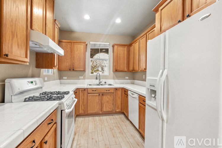 A kitchen with wooden cabinets and white appliances.