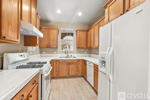A kitchen with wooden cabinets and white appliances.