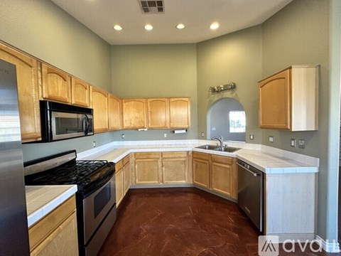 A kitchen with wooden cabinets and a stainless steel dishwasher.