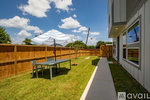 A patio with a table and chairs is surrounded by a wooden fence.