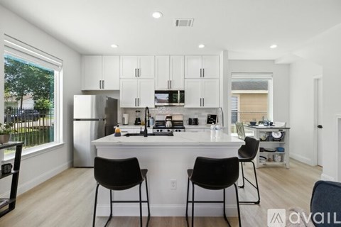 A modern kitchen with white cabinets and a center island.