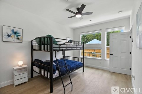 A bedroom with a bunk bed and a ceiling fan.