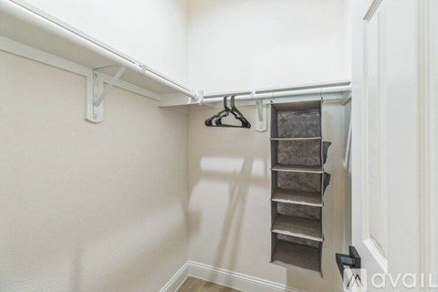 A white closet with a metal rail and shelves.