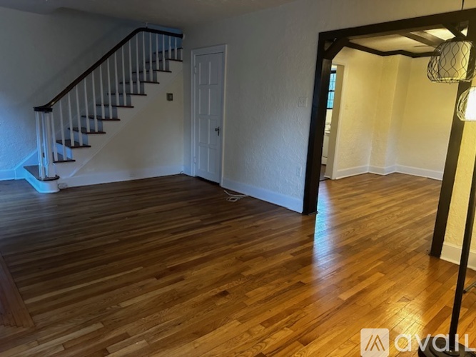 A room with wooden flooring and a staircase.