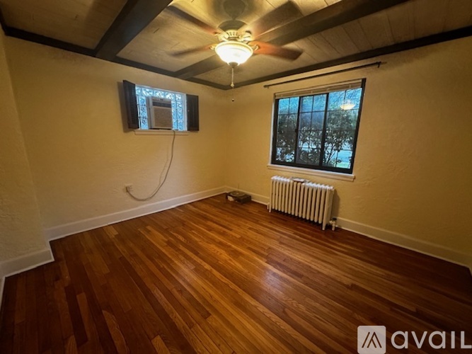 A room with wooden floors and a ceiling fan.