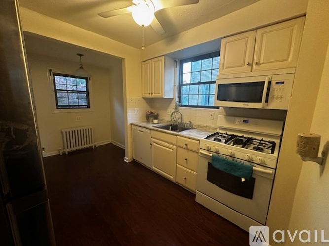 A kitchen with white cabinets and a black stove top.