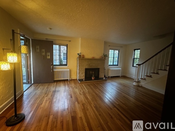 A living room with wood floors and a fireplace.