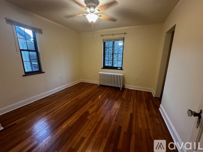 A room with wooden floors and a ceiling fan.