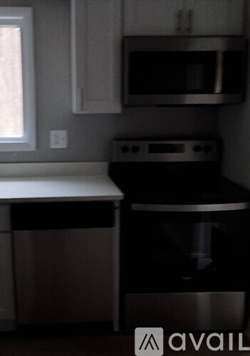 A living room with a grey couch, a white coffee table, a flat screen TV, and a ceiling fan.