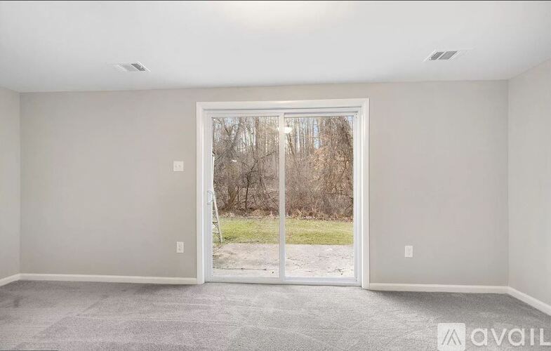 A room with a large door leading to a backyard.