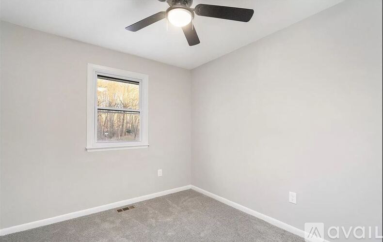A room with a ceiling fan and a window.