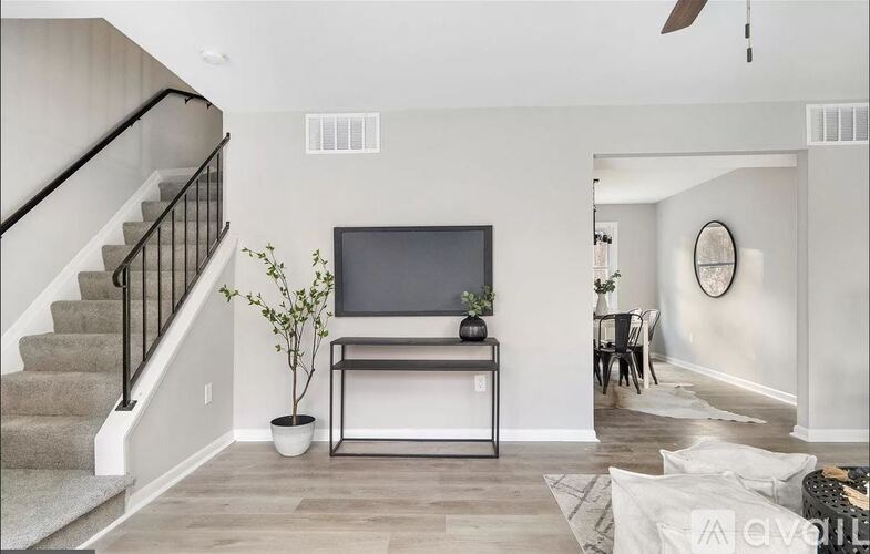 A living room with a television and a staircase.
