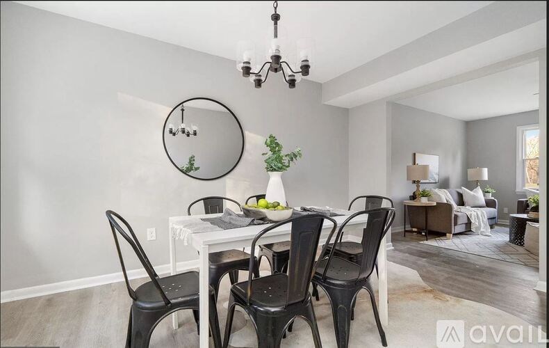 A dining room with a white table and black chairs.