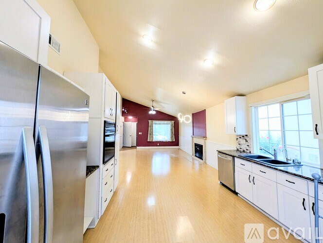 A kitchen with white cabinets and a stainless steel refrigerator.