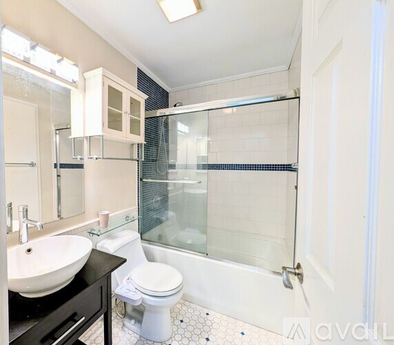 A bathroom with a toilet, sink, and shower.
