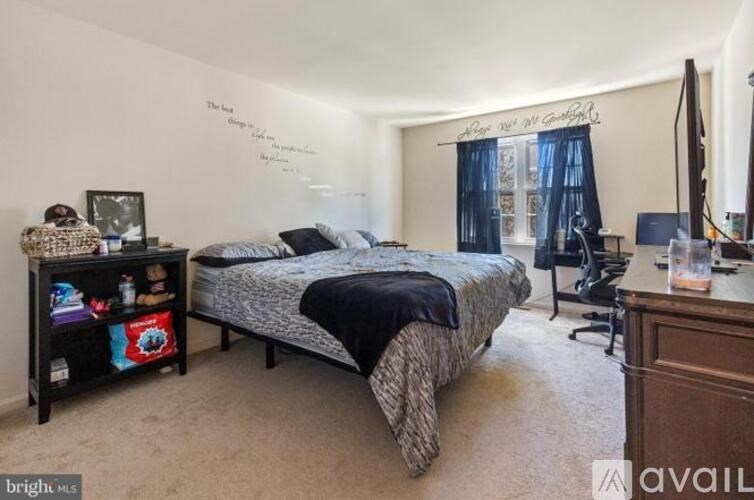 A bedroom with a bed, desk, and chair.