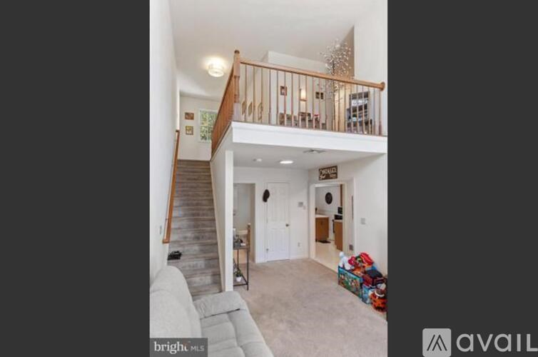 A living room with a couch and a staircase.