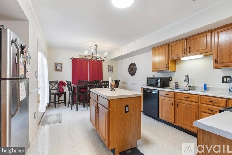 A kitchen with wooden cabinets and a black dishwasher.