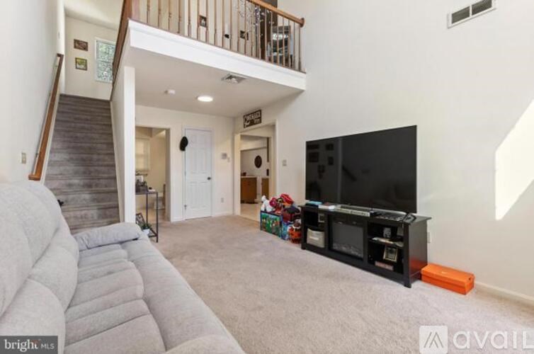 A living room with a grey sofa and a black television.
