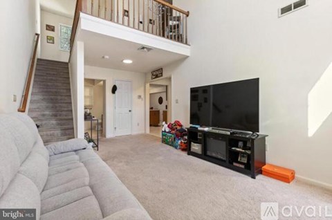 A living room with a grey sofa and a black television.
