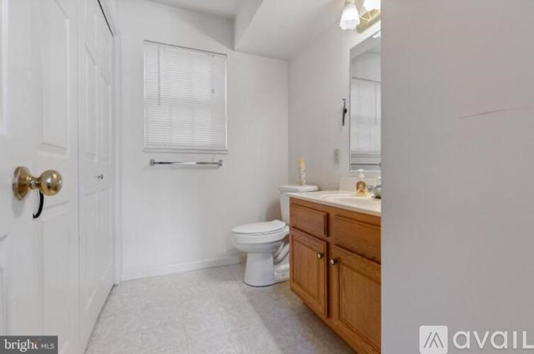 A bathroom with a toilet, sink, and a door.