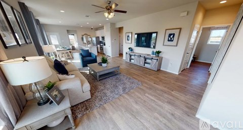 A well-lit living room with a ceiling fan and a couch.