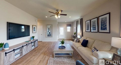 A living room with a television, couch, and decorative pillows.