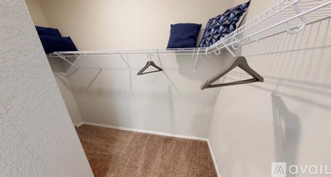 A white wall with a shelf and two pillows.