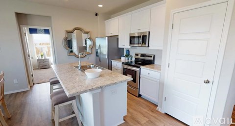 A kitchen with white cabinets and a granite countertop.
