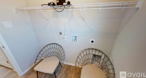 A room with a white wall and a chair with a white cushion.