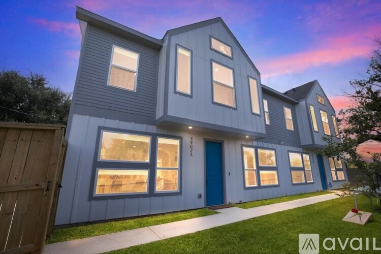 A modern house with a blue door and windows is available for purchase.