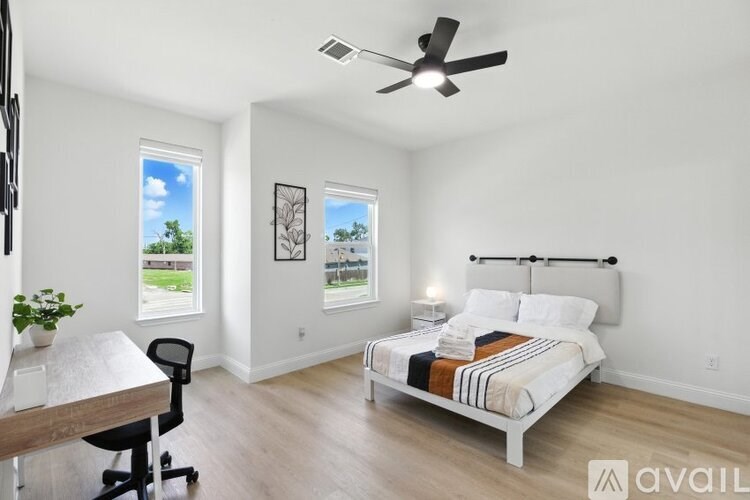 A bedroom with a bed, desk, and chair.