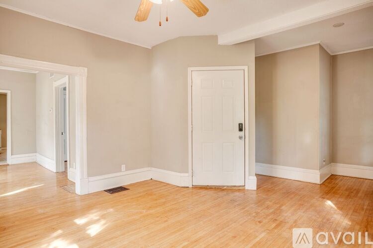 A room with a white door and a ceiling fan.