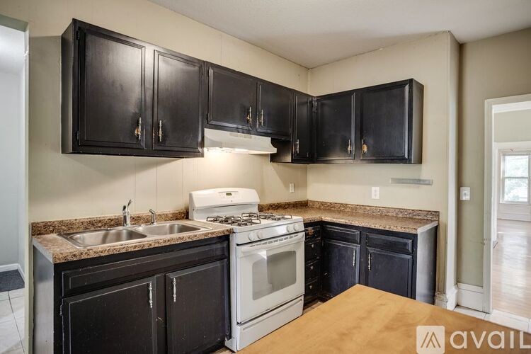 A kitchen with black cabinets and a white stove top oven.
