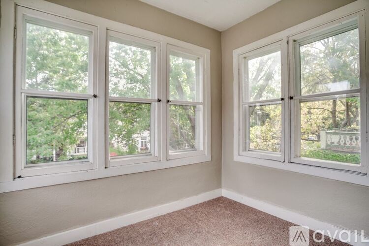 A room with three windows and a carpeted floor.