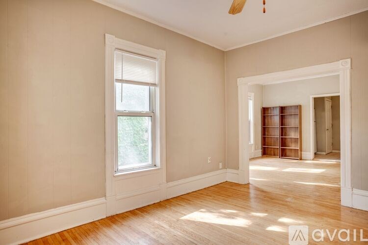 A room with a window and a fan on the ceiling.