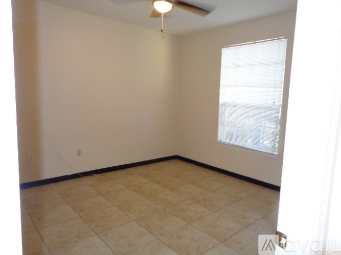 A room with a fan and a window.