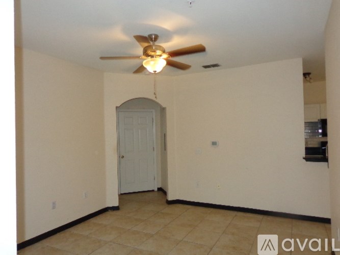 A room with a ceiling fan and a door.