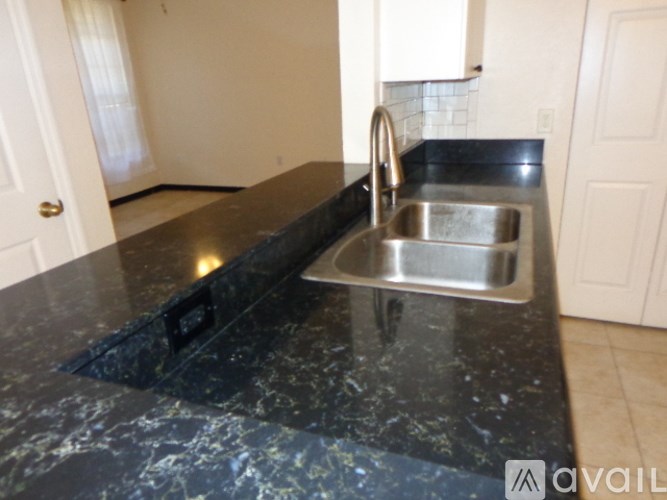 A kitchen counter with a sink and a faucet.