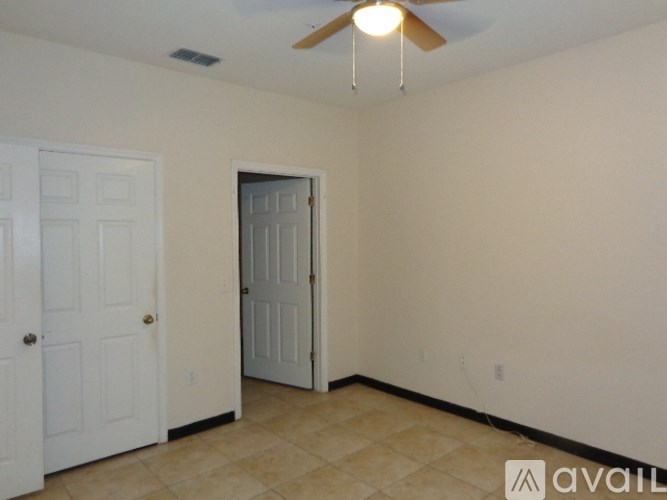 A room with a ceiling fan and two doors.