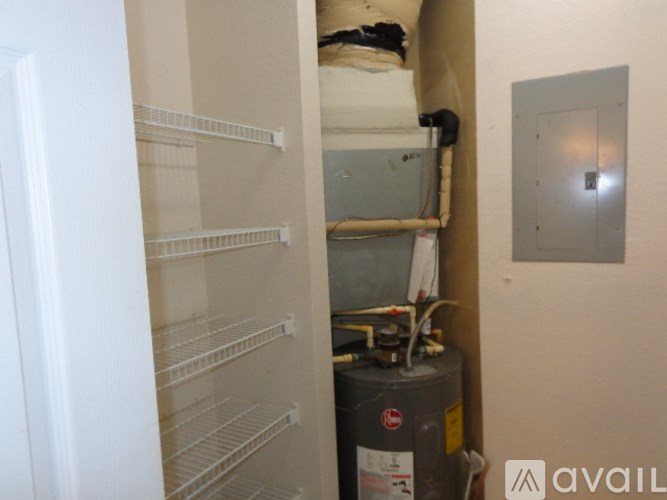 A white door with a shelving unit inside and a gas tank below it.